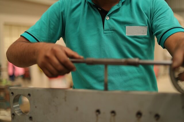 Skilled worker doing manual tapping in zig fixture